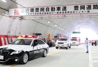 通り初めでトンネル内を走るパトカーなど＝豊岡市戸牧