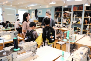 かばん作りを学べる工房を見学する親子連れ＝豊岡市中央町