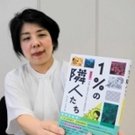 豊岡市と神戸大学の共同研究をまとめた「１％の隣人たち」と、インタビューが掲載されている豊岡市職員の木内純子さん＝同市役所