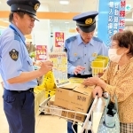 特殊詐欺を防ぐ効果があるとされる電話機の購入補助をＰＲする警察官たち＝豊岡市加広町