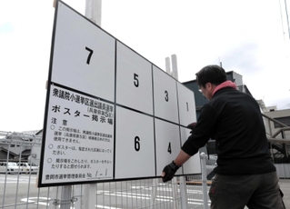 衆院選のポスター掲示板を設置する作業員＝豊岡市中央町