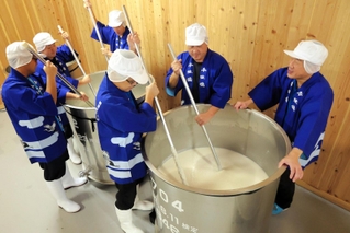 タンクの酒母をかき混ぜる蔵人たち＝香住鶴