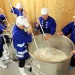 タンクの酒母をかき混ぜる蔵人たち＝香住鶴