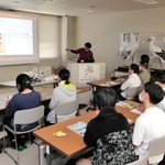 コウノトリやほかの動物の義肢装具の作成事例などについて話を聞く生徒たち＝豊岡市祥雲寺