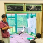 けがをしたコウノトリと、松本獣医師（左）の話を聞く生徒＝豊岡市祥雲寺