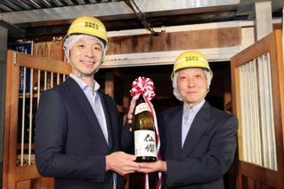 蔵出しした仙櫻を手にする山陽盃酒造の壺阪雄一専務（左）と今井久雄養父副市長＝養父市大屋町明延