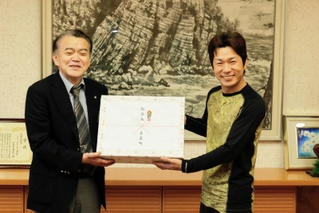 浜上勇人町長（左）から記念品を受け取る漁師２年目の角和紀さん＝香美町役場