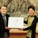 浜上勇人町長（左）から記念品を受け取る漁師２年目の角和紀さん＝香美町役場