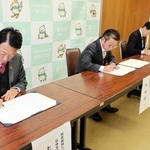 協定書にサインをする（手前から）損害保険ジャパンの上山英也兵庫支店長、大林賢一市長、ＳＯＭＰＯひまわり生命保険の山本健太郎兵庫支社長＝養父市八鹿町八鹿