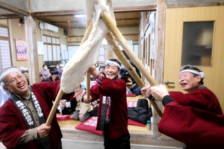 最後は祝い歌に合わせて、杵に絡めた餅を頭上に持ち上げた＝香美町香住区守柄