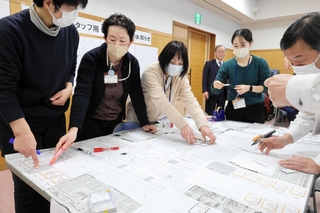 「犬を連れた避難者１人です」「トイレが断水しています」。次々と読み上げられるイベントや避難者に対応するプレーヤーたち＝新温泉町湯