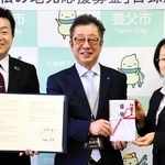 協定を結んだ（左から）坪井良英・明治安田生命保険相互会社姫路支社長、大林賢一養父市長、長谷川誓子・同社執行役員近畿地域リレーション本部長＝養父市八鹿町八鹿