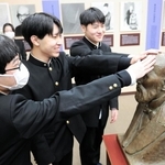 加藤弘之の胸像をなでて、ご利益にあやかる受験生たち＝出石明治館