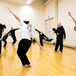 演者たちの輪の中で、舞踏を指導する大駱駝艦の田村一行さん＝豊岡市大手町