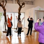 展示される像の前でポーズを取る同級生を撮影する児童＝あさご芸術の森美術館