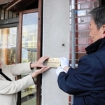 県の景観遺産に登録された復興建築の建物に記念プレートが取り付けられた谷山人形店＝豊岡市中央町