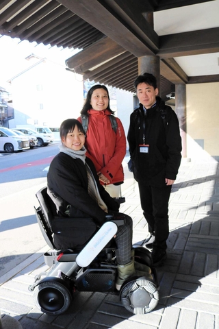 城崎温泉街でレンタルできるようになった電動車いすと、ユニバーサルツーリズムセンター準備室の運営スタッフたち＝豊岡市城崎町湯島