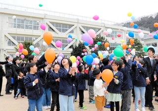 閉校行事で、風船を飛ばす子どもたち＝豊岡市竹野町竹野