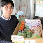 地元の生産者から届いた商品を手にする遠藤真森さん＝豊岡市中央町