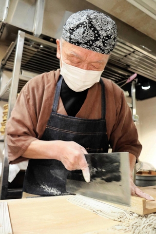 練り上げたそばを切る安藤一美さん＝豊岡市日高町栗栖野、道の駅「神鍋高原」
