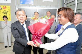 香美町長選で当選確実となり花束を受け取る浜上勇人氏＝香美町香住区香住