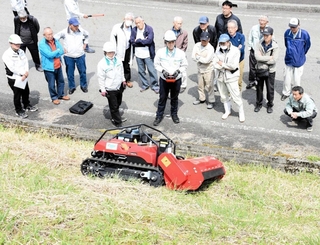 ラジコン式草刈り機の説明を聞く住民ら＝朝来市和田山町