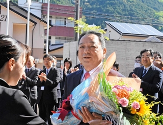 職員に花束を贈られる２期目初登庁の藤岡勇・朝来市長＝同市役所