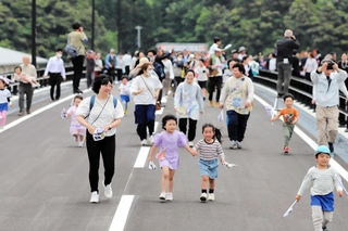 新しい城崎大橋の渡り初めに臨む住民たち＝豊岡市城崎町