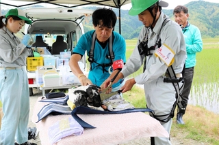 コウノトリのひなの足に識別用の足輪を付ける獣医師や飼育員たち＝豊岡市赤石