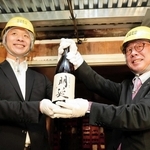 蔵出しした純米酒「明延」を掲げる（左から）山陽盃酒造の壺阪雄一専務と大林賢一養父市長＝養父市大屋町明延