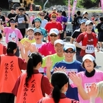 村岡高校生とハイタッチして出発するランナーたち＝香美町小代区野間谷