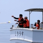 海防艦２隻が沈む海に卒塔婆を投げ入れる参列者たち＝香住沖