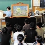 子どもたちに満州開拓団の紙芝居を読み聞かせる「語り継ぐ会」の語り手たち＝豊岡市但東町出合市場