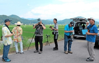 全国から集まった愛鳥家にコウノトリの魅力を説明する元飼育員の久下直哉さん（右端）＝豊岡市立野