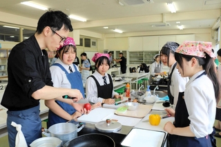 料理家でユーチューバーのガンガンさんから、地元食材を使った料理を教わる高校生たち＝豊岡市加広町