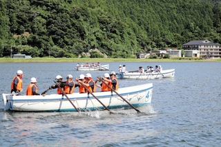 力強くオールをこぐ選手たち＝豊岡市小島