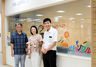スタジオ前でクラウドファンディングをＰＲするＦＭジャングルのパーソナリティー＝豊岡市大手町