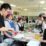 料理家でユーチューバーのガンガンさんから、地元食材を使った料理を教わる高校生たち＝豊岡市加広町