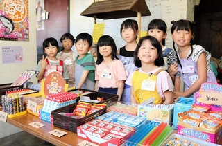 １８～２４日に豊岡劇場ロビーに開店する駄菓子店で、店員を務める小学生たち＝豊岡市元町