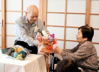 講演し、妻らから花束を受け取る山下幸雄さん＝豊岡市但東町中山