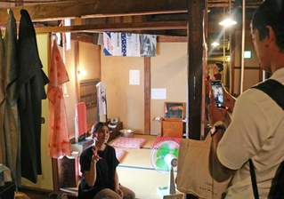 実際に映画で使われた鏡台（中央）を展示した楽屋で記念撮影する観光客＝豊岡市出石町柳