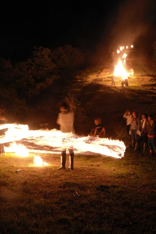 点火した万灯が並ぶ山の裾で、火の付いた麦わらの束を振り回す「振り万灯」が披露された＝養父市三宅