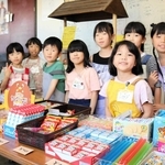 １８～２４日に豊岡劇場ロビーに開店する駄菓子店で、店員を務める小学生たち＝豊岡市元町