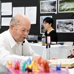 殉難者３４６人の名前を読み上げる山下幸雄さん＝豊岡市但東町久畑