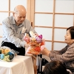 講演し、妻らから花束を受け取る山下幸雄さん＝豊岡市但東町中山