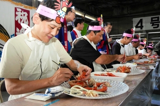 香住ガニ食べ方上手選手権で、カニを素早く食べる参加者ら＝香美町香住区若松