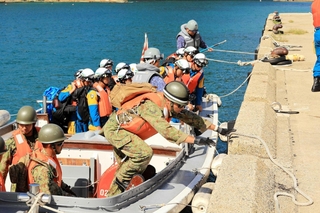 小型艇で上陸する陸上自衛隊員や愛知県警の機動隊員ら＝豊岡市竹野町竹野