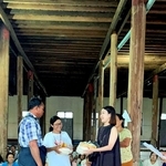 講堂に集まった住民に食糧を配る田中かのんさん（右）＝８月３日、ミャンマー・ニャウンシェのインレー湖（田中さん提供）