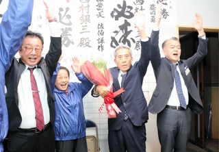 当選確実の知らせを受け、バンザイする西村銀三氏＝新温泉町湯（撮影・阿部江利）