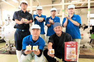 円山川のシジミを使った缶詰を開発した村尾成介さん（手前右）と香住高校の生徒ら＝香住高校